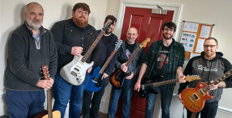 Group of people with guitars that have finished a guitar tech setup and repair course in Leeds